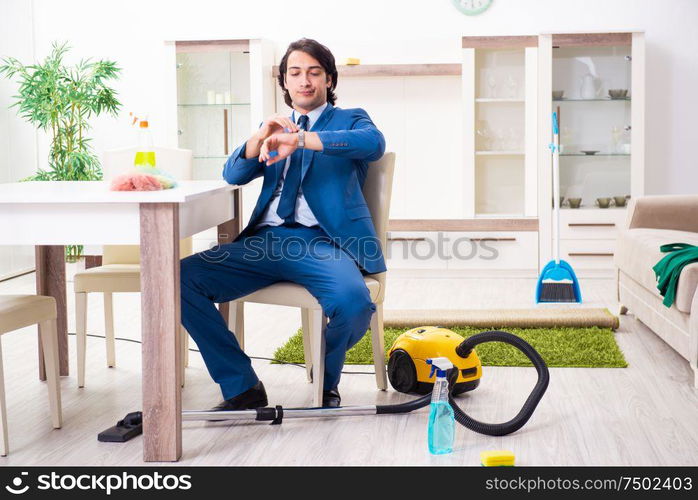 The young businessman cleaning the house. Young businessman cleaning the house