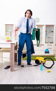 The young businessman cleaning the house. Young businessman cleaning the house