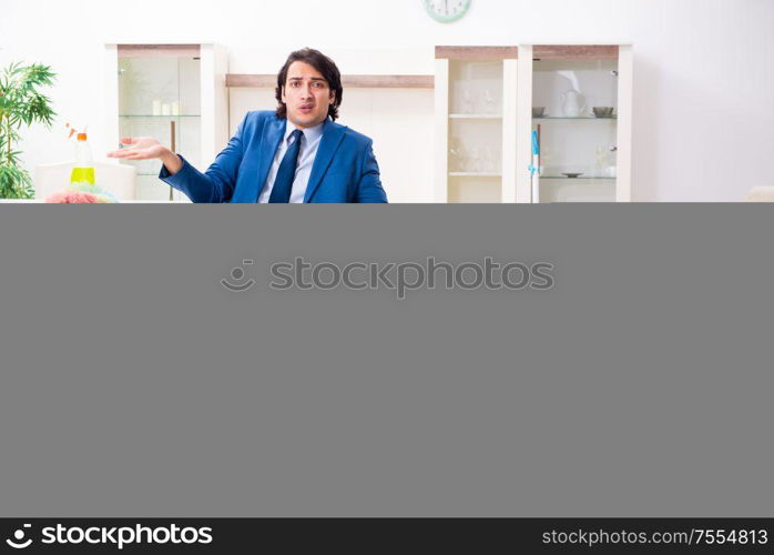 The young businessman cleaning the house. Young businessman cleaning the house