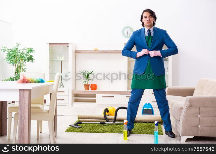 The young businessman cleaning the house. Young businessman cleaning the house