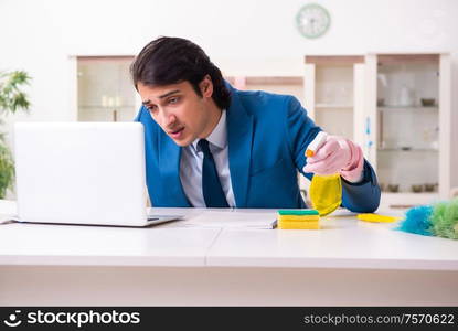 The young businessman cleaning the house. Young businessman cleaning the house