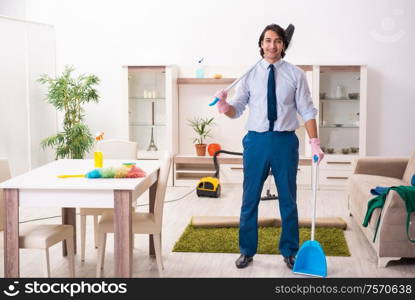 The young businessman cleaning the house. Young businessman cleaning the house