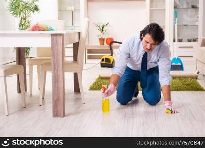 The young businessman cleaning the house. Young businessman cleaning the house