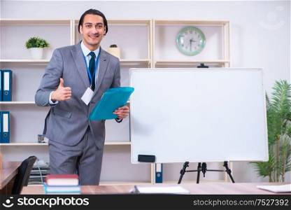 The young businessman standing in front of white board. Young businessman standing in front of white board
