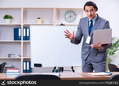 The young businessman standing in front of white board. Young businessman standing in front of white board