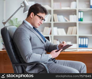 The young businessman working in the office. Young businessman working in the office