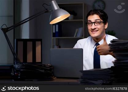 The young businessman working overtime late in office. Young businessman working overtime late in office
