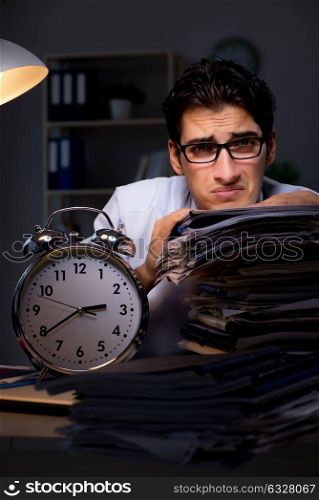 The young businessman working overtime late in office. Young businessman working overtime late in office