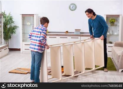 The young carpenter teaching his son . Young carpenter teaching his son 