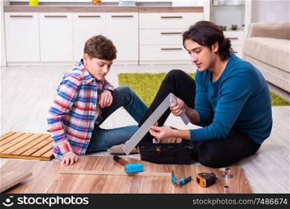 The young carpenter teaching his son . Young carpenter teaching his son