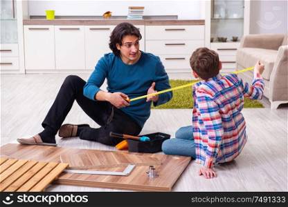 The young carpenter teaching his son. Young carpenter teaching his son