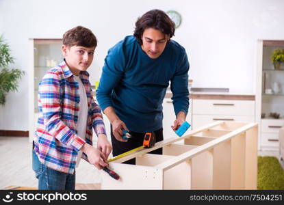 The young carpenter teaching his son. Young carpenter teaching his son