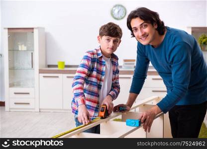 The young carpenter teaching his son. Young carpenter teaching his son