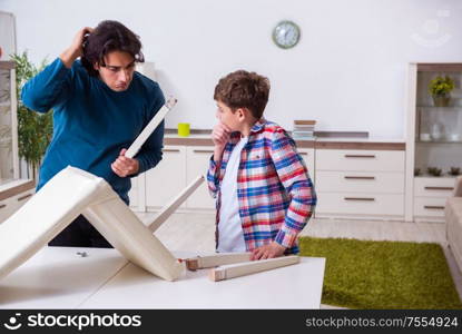 The young carpenter teaching his son. Young carpenter teaching his son