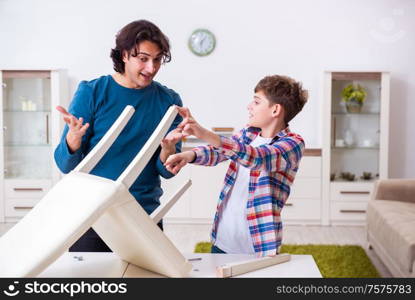 The young carpenter teaching his son. Young carpenter teaching his son