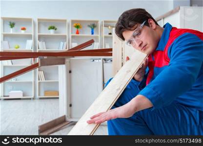 The young carpenter working with wooden planks. Young carpenter working with wooden planks