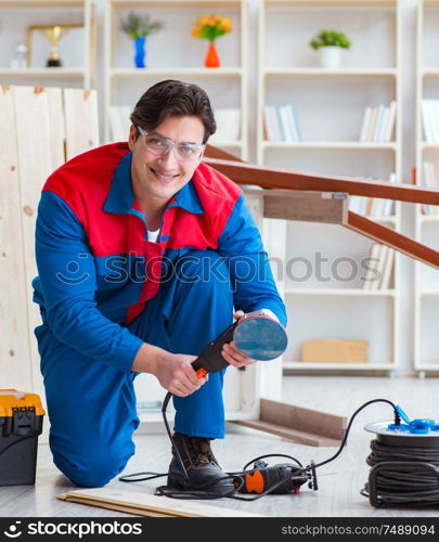 The young carpenter working with wooden planks. Young carpenter working with wooden planks