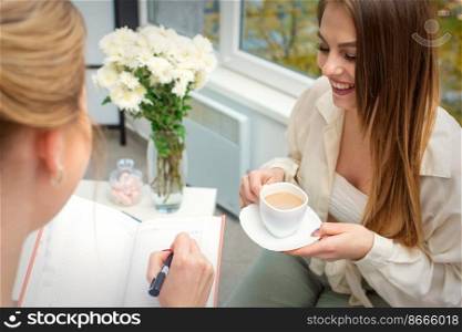 The young caucasian woman has a coffee and appointment with a female doctor in hospital office. The young caucasian woman has a coffee and appointment with a female doctor in hospital office.