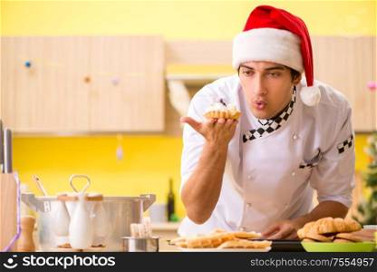 The young chef husband working in kitchen at christmas eve. Young chef husband working in kitchen at Christmas eve