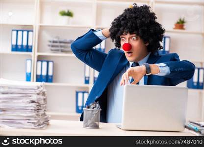 The young clown businessman working in the office . Young clown businessman working in the office