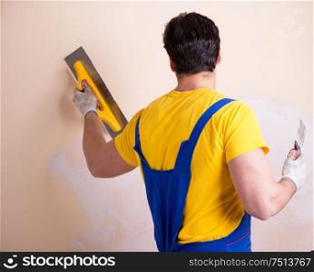 The young contractor employee applying plaster on wall. Young contractor employee applying plaster on wall