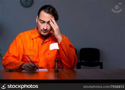The young convict man sitting in dark room. Young convict man sitting in dark room