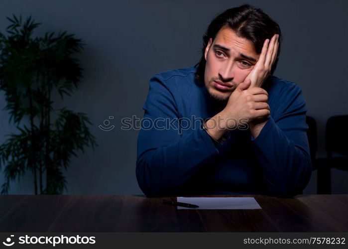 The young convict man sitting in dark room. Young convict man sitting in dark room