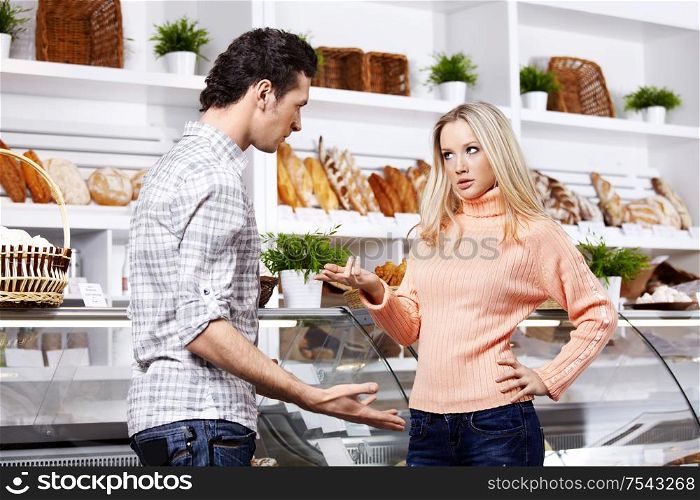 The young couple argues in grocery shop