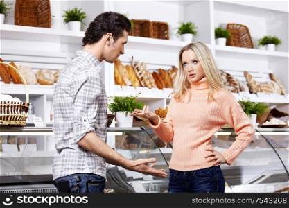 The young couple argues in grocery shop
