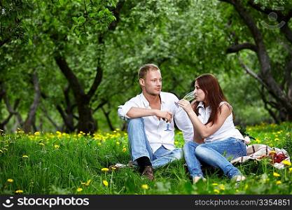 The young couple drinks champagne in park
