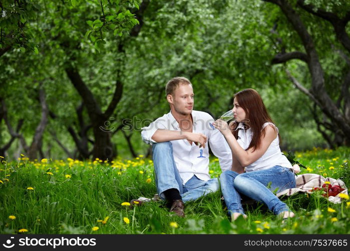 The young couple drinks champagne in park