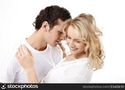 The young couple embraces on a white background