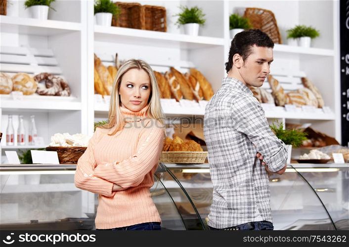 The young couple has turned away from each other in shop