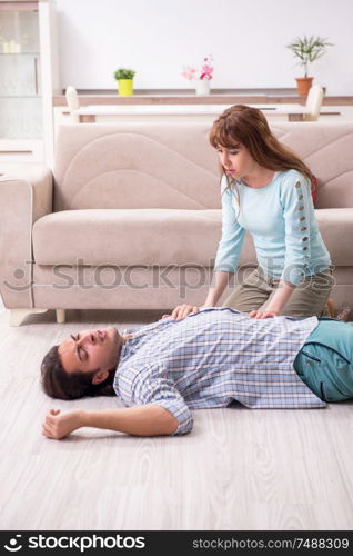 The young couple in first aid concept at home . Young couple in first aid concept at home