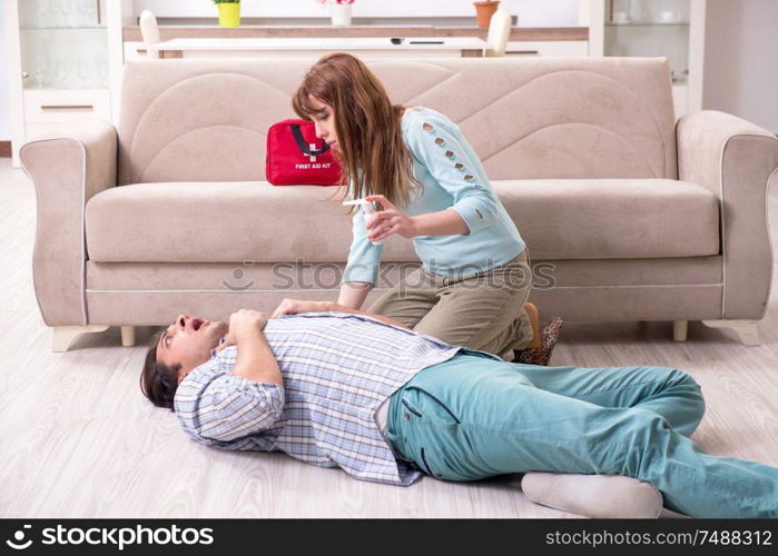 The young couple in first aid concept at home. Young couple in first aid concept at home