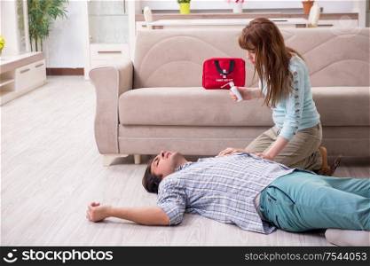 The young couple in first aid concept at home. Young couple in first aid concept at home