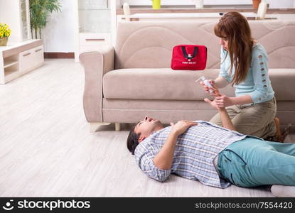 The young couple in first aid concept at home. Young couple in first aid concept at home