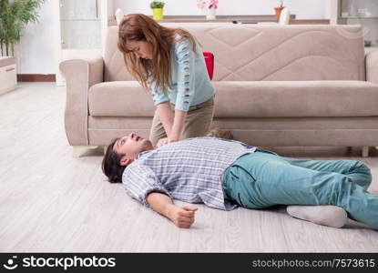 The young couple in first aid concept at home. Young couple in first aid concept at home