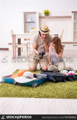 The young couple preparing for trip . Young couple preparing for trip