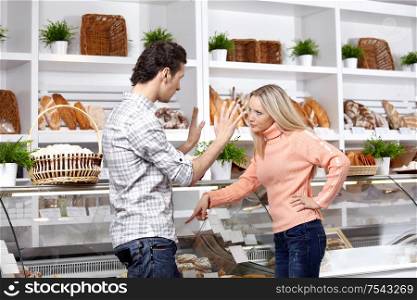 The young couple quarrels in a baker?s shop