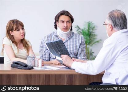 The young couple visiting old male doctor. Young couple visiting old male doctor