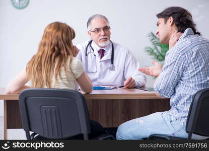 The young couple visiting old male doctor. Young couple visiting old male doctor