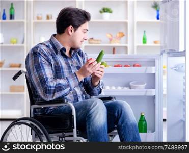 The young disabled injured man opening the fridge door. Young disabled injured man opening the fridge door