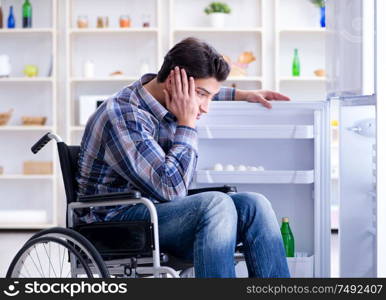 The young disabled injured man opening the fridge door. Young disabled injured man opening the fridge door