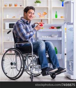 The young disabled injured man opening the fridge door. Young disabled injured man opening the fridge door