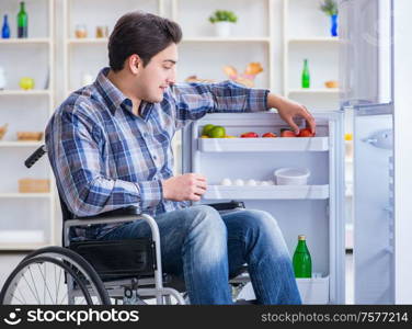 The young disabled injured man opening the fridge door. Young disabled injured man opening the fridge door