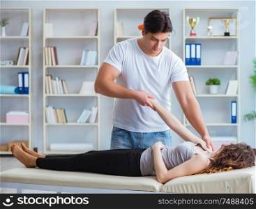 The young doctor chiropractor massaging female patient woman. Young doctor chiropractor massaging female patient woman