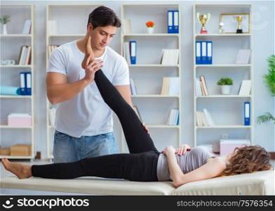 The young doctor chiropractor massaging female patient woman. Young doctor chiropractor massaging female patient woman