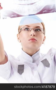 The young doctor examines an x-ray on a white background