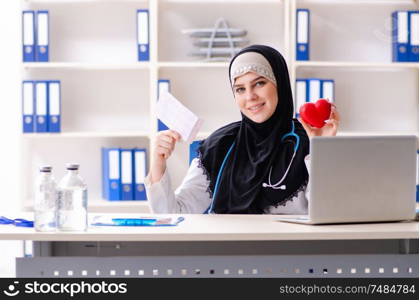 The young doctor in hijab working in the clinic . Young doctor in hijab working in the clinic